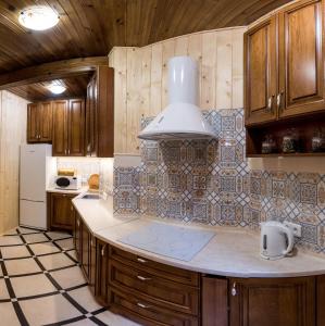 a kitchen with wooden cabinets and a counter top at Лісовий Маєток in Slavske