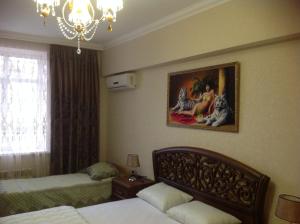 エッセントゥキにあるАпартаменты на улице Ленина 14Бのベッドルーム1室(ベッド2台付)が備わります。壁には絵画が飾られています。