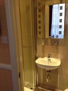a bathroom with a sink and a shower at Balmoral House Hotel in London
