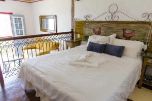 a white bed with a tray of food on it at Pousada Vila Mineira in Lavras Novas