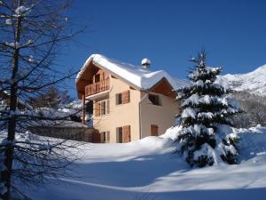 a snow covered house with a snow covered christmas tree at Le Maurillon in Saint-Pancrace
