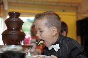 un joven comiendo comida de un tazón en Wellness Pension & Salaš Šariš Park, en Prešov