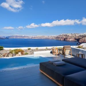 a villa with a pool and a view of the ocean at Neptune Luxury Suites in Akrotiri