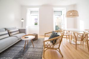 ein Wohnzimmer mit einem Sofa und einem Tisch in der Unterkunft FLH Madragoa Bright Place in Lissabon
