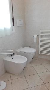 a white bathroom with a toilet and a bidet at Beva Fiera Bologna in Bologna +5 photos