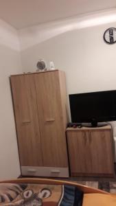 um quarto com 2 armários de madeira e uma televisão de ecrã plano em Rooms Adrijana em Banja Luka