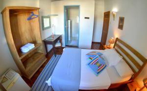 a bedroom with a large white bed and a desk at Pousada Baluarte in Salvador