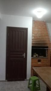 a black door in a room with a green stool at Sobrado Em Matinhos Pr in Matinhos