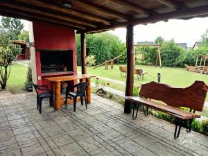 un patio con mesa, chimenea y banco en Ensueño Cabañas en Los Reartes