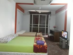 a bedroom with two beds and a flat screen tv at Nueva Alborada Lodging House in Fernando de la Mora