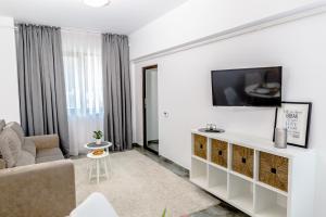 a living room with a couch and a tv on a wall at ConceptHT Regim Hotelier in Iaşi
