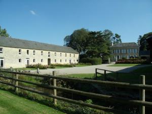 een hek voor een groot gebouw bij Chambres d'Hôtes La Fresnée in Mosles