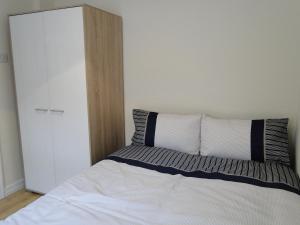a bedroom with a bed with two pillows and a closet at Tri Ard House Derry City Centre town house in Derry Londonderry +3 photos