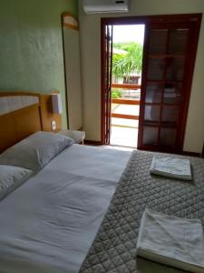 ein Bett mit zwei Handtüchern darauf in einem Schlafzimmer in der Unterkunft Pousada Esquina do Sol in Rio Grande