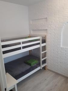 コルドバにあるCorredera Home Parking Casco Histórico Córdobaの白レンガの壁の客室で、二段ベッド1組が備わります。