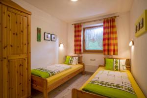 2 łóżka w małym pokoju z zieloną i białą kolorystyką w obiekcie Ferienwohnungen Gruber w mieście Hart im Zillertal