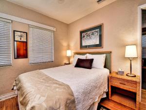 1 dormitorio con 1 cama con 2 lámparas y 2 ventanas en Palm Place 3 - Buccaneer Palm Beach getaway 622, en Clearwater Beach