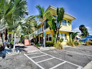 クリアウォーター・ビーチにあるPalm Place 2 - Coconut Palm Beach getaway 623の駐車場のヤシの木がある黄色い家