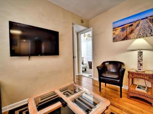 sala de estar con mesa de centro de cristal y silla en Palm Place 4- Royal Palm 621, en Clearwater Beach