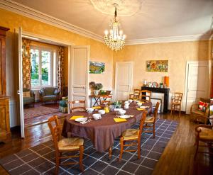 a dining room with a table and chairs and a chandelier at La Fresnée chambres d'hôtes in Mosles +16 photos