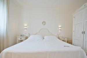 a white bedroom with a white bed with white sheets at Borgobianco Resort & Spa Polignano - MGallery Collection in Polignano a Mare