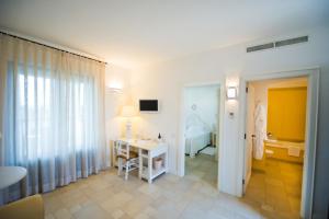 a bathroom with a sink and a room with a bed at Borgobianco Resort & Spa Polignano - MGallery Collection in Polignano a Mare