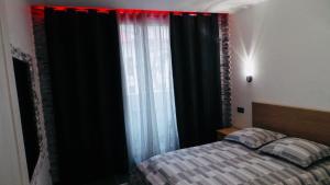 a bedroom with a bed and a window with black curtains at Catalans in Marseille