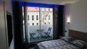 a bedroom with a bed and a window with chairs at Catalans in Marseille