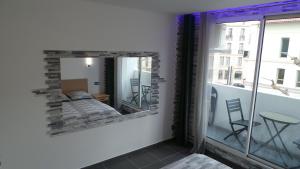 a mirror in a room with a bed and a balcony at Catalans in Marseille