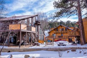 a log cabin in the winter with snow on the ground at Murphy's River Lodge in Estes Park