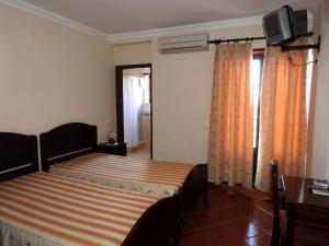 1 dormitorio con 1 cama con cortina naranja en Aqui Jardim, en Reguengos de Monsaraz