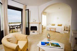 a bedroom with a bed and a living room with a table at Borgobianco Resort & Spa Polignano - MGallery Collection in Polignano a Mare