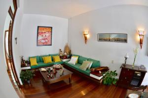 Pousada Baluarte في سلفادور: غرفة معيشة مع أريكة خضراء وطاولة
