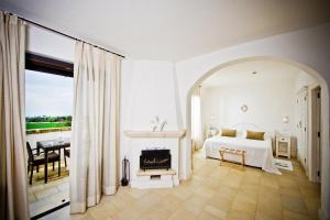 a white bedroom with a bed and a fireplace at Borgobianco Resort & Spa Polignano - MGallery Collection in Polignano a Mare