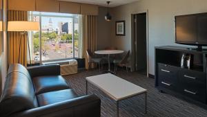 uma sala de estar com um sofá, uma televisão e uma mesa em Holiday Inn St. Paul Downtown, an IHG Hotel em Saint Paul