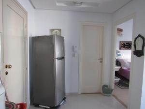 a kitchen with a stainless steel refrigerator in a room at Apartment Essayadi Residence in Port El Kantaoui