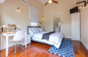 a bedroom with a bed and a desk and a table at 99 Kirkland Bed & Breakfast in Brisbane