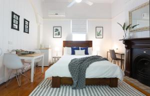 a bedroom with a bed, desk, chair, and lamp at 99 Kirkland Bed & Breakfast in Brisbane