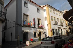 a white car parked in front of a building at Burgos Guest House in Évora