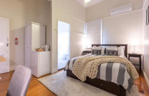 a bedroom with a bed and a dresser at 99 Kirkland Bed & Breakfast in Brisbane