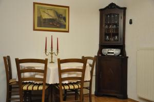 a dining room with a table with chairs and a clock at Apartments Ananina in Portorož
