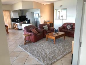 a living room with two couches and a coffee table at OceanScape Luxury Beachfront Villas in Scotts Head