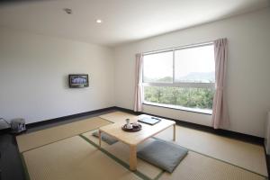 a living room with a table and a large window at Hotel Innoshima in Onomichi