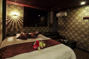 a hotel room with a bed with flowers on it at Hotel Cube (Love Hotel) in Kitakyushu