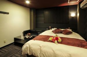 Un dormitorio con una cama grande con flores. en Hotel Cube (Love Hotel), en Kitakyushu