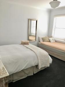 a bedroom with a bed and a mirror and a window at 99 Hill Street Apartments in Orange