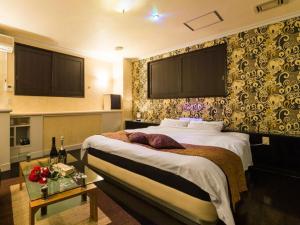 um quarto de hotel com uma cama e uma mesa em Hotel TiAMO (Love Hotel) em Kitakyushu