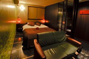 une chambre avec un lit, un canapé et une chaise dans l'établissement Hotel Yarma (Adult Only), à Shimonoseki