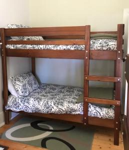 two bunk beds in a room with a rug at Armadale House - Kingscote in Kingscote