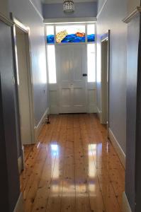 a hallway with a wooden floor and a stained glass window at Armadale House - Kingscote in Kingscote